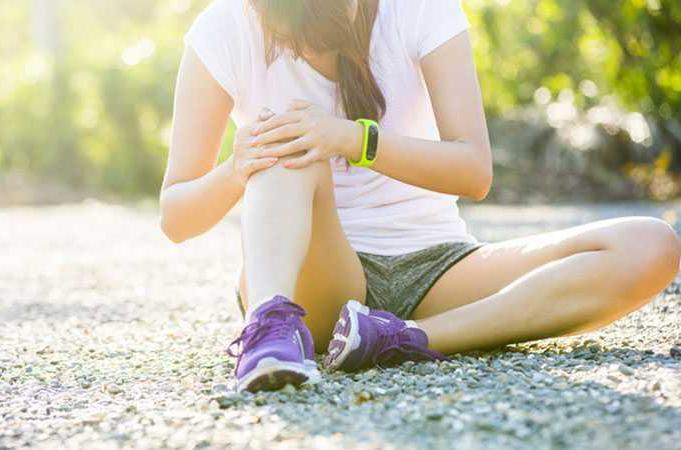 Woman on the ground with knee pain during running.