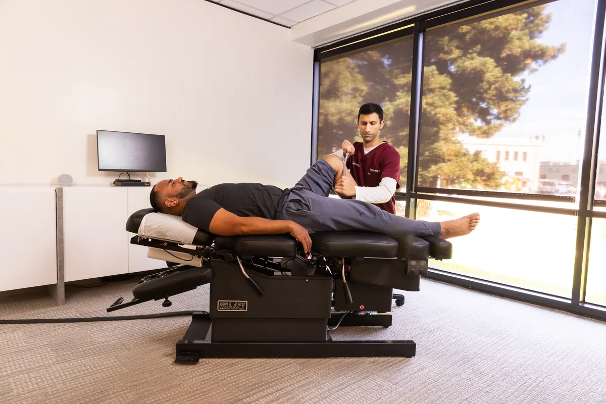 Dr. Supreet Shah adjusting a patient's hip and low back on a chiropractic table at TruSpine San Francisco