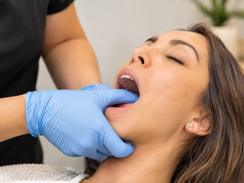 Truspine chiropractor performing intraoral masseter release for TMJ jaw pain in San Francisco